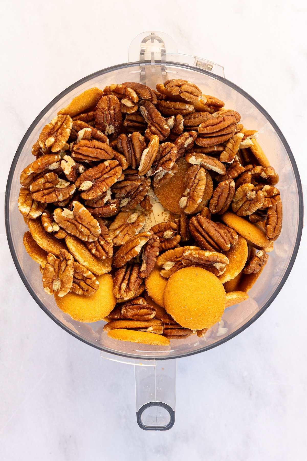 cookies and pecans in food processor bowl