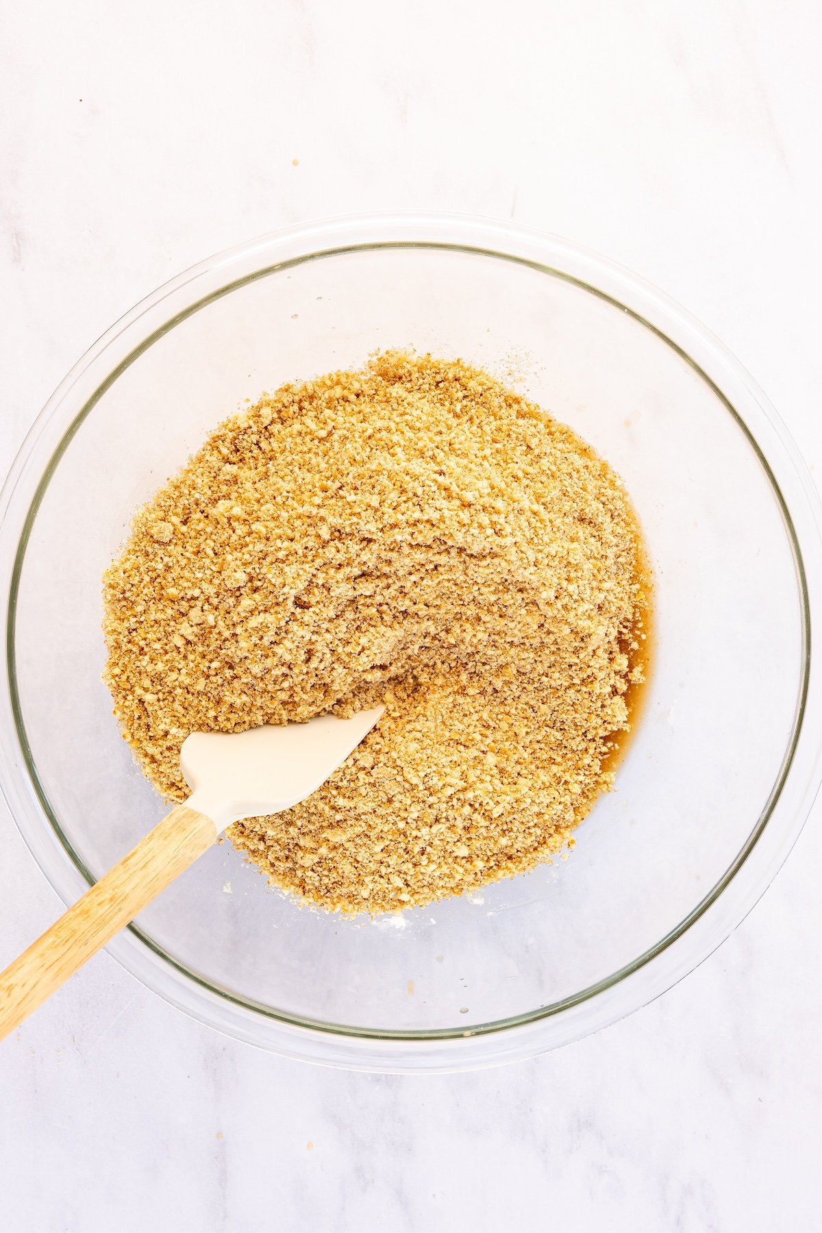 cookie mixture added to wet ingredients in glass bowl