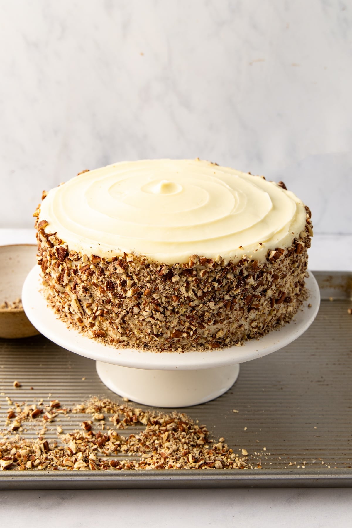 cake with chopped pecans covering the side