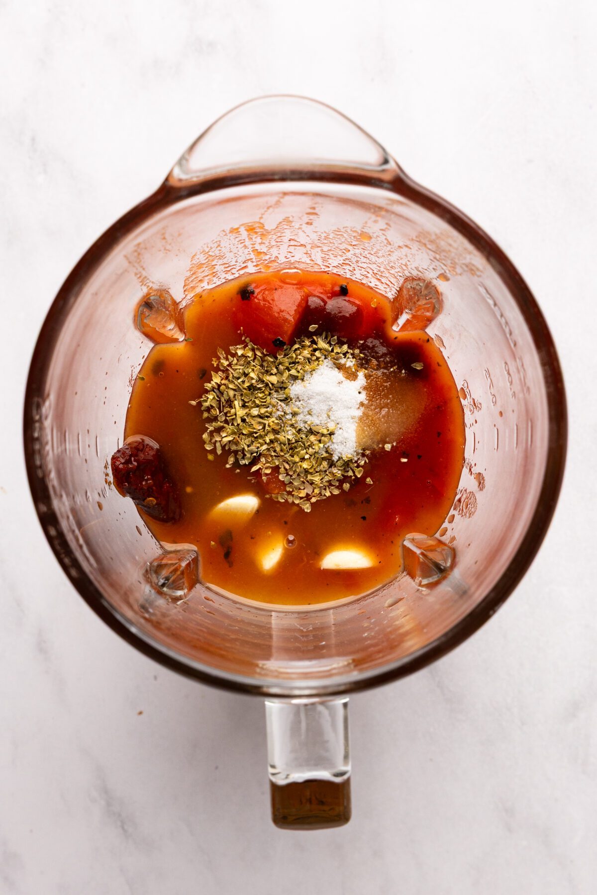 blender with oregano, garlic, broth, salt and sugar added to tomato mixture