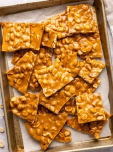 pieces of peanut brittle on parchment-lined baking sheet