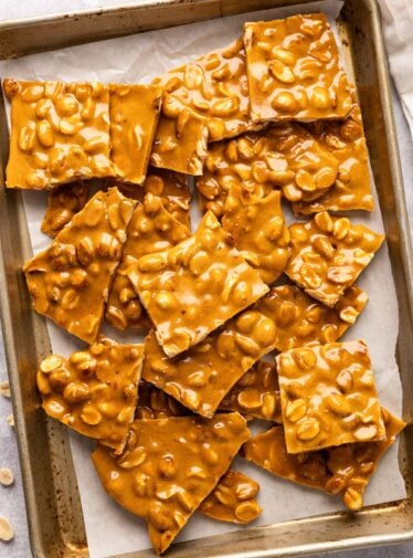 pieces of peanut brittle on parchment-lined baking sheet