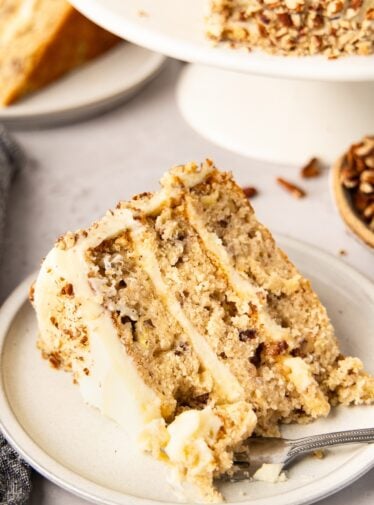 Slice of hummingbird cake on a white plate.