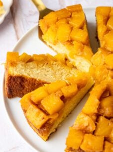 Pineapple upside-down cake sliced on platter.