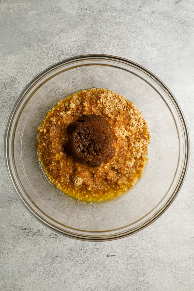 medium glass bowl with brown sugar, melted butter, and nilla wafer crumbs