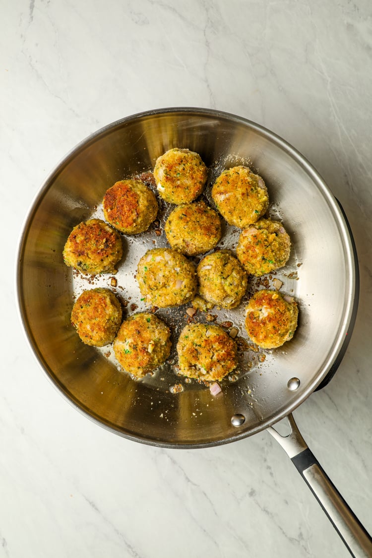 large skillet with browned chicken piccata meatballs