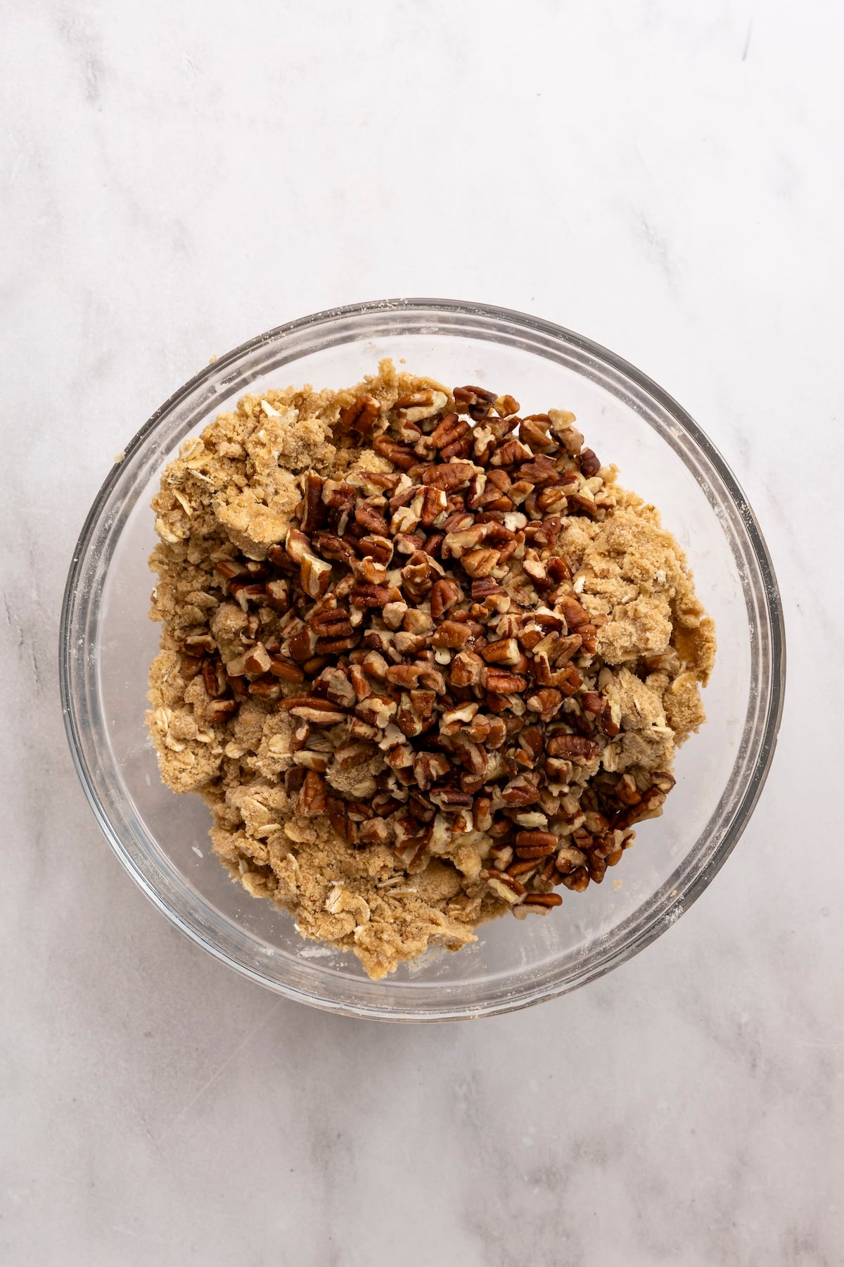 medium bowl with pecans added to flour/oat/brown sugar mix