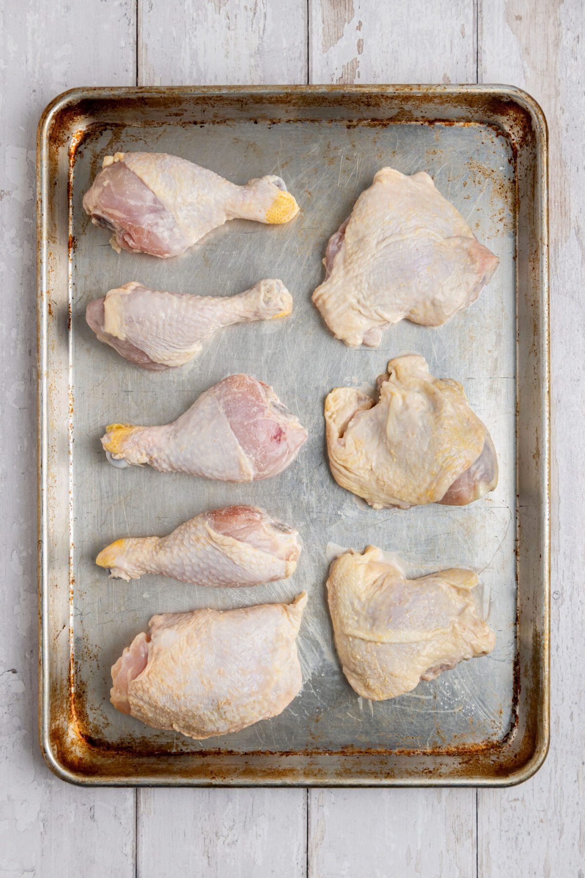 brined chicken pieces on baking sheet