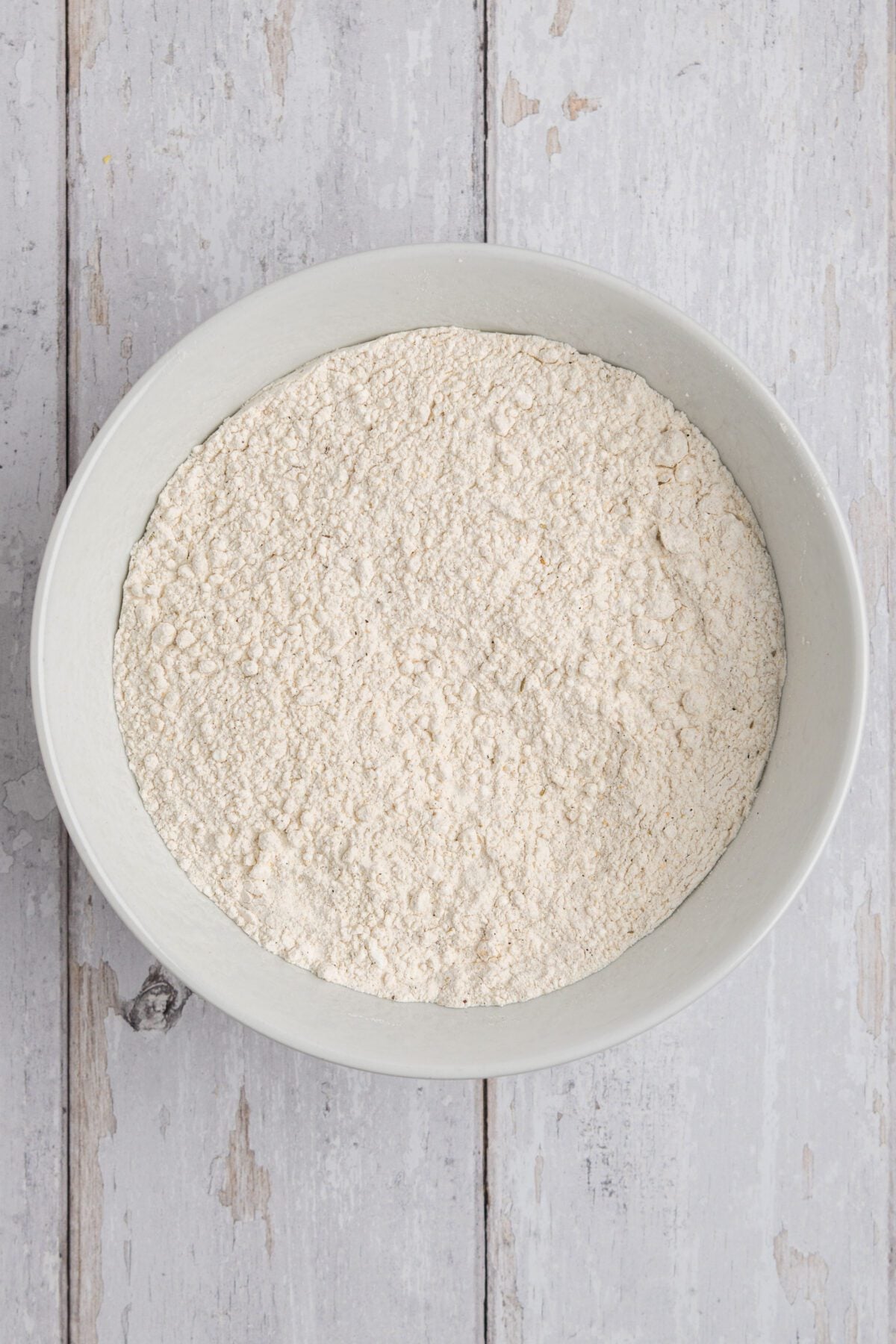 large bowl with flour, cornstarch, salt, pepper, garlic powder, onion powder, smoked paprika, thyme, and Accent/sazon seasoning