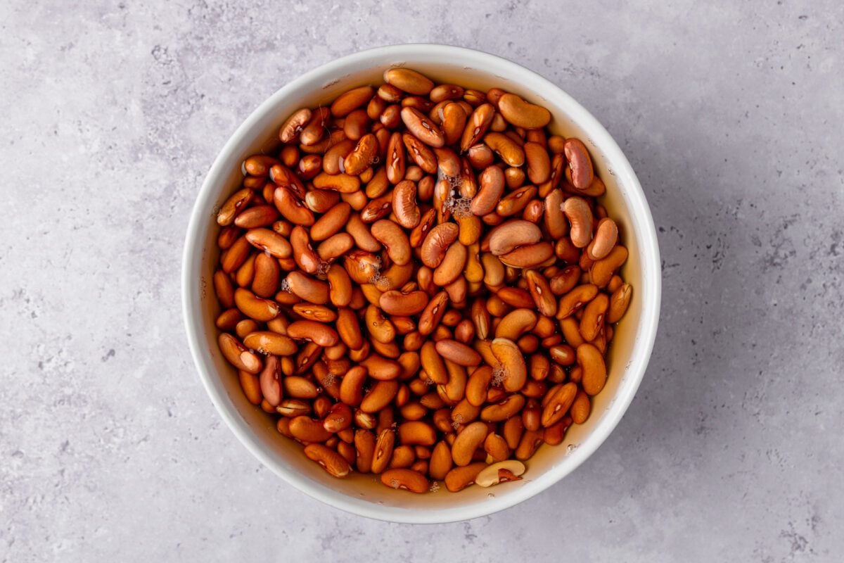 large bowl with red pinto beans soaking in water
