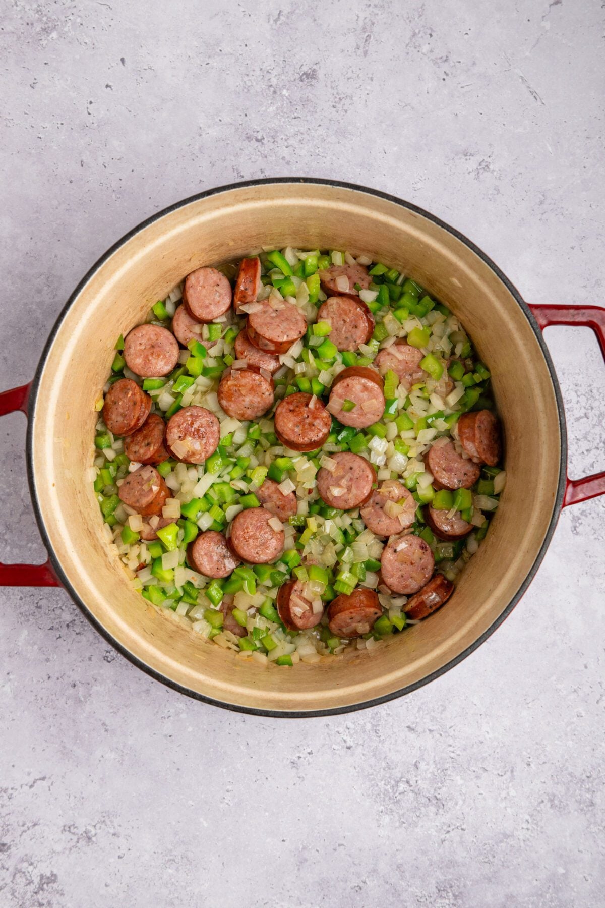 dutch oven with onion, bell pepper, celery, and garlic added to browned sausage.