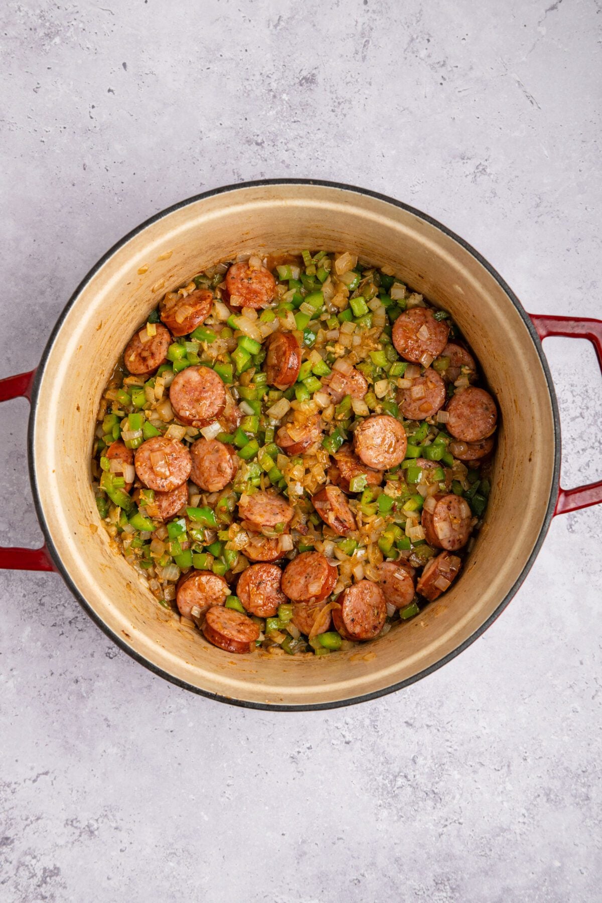 dutch oven with thyme, smoked paprika, salt, cayenne pepper, and black pepper added to sausage and cooked onion mixture
