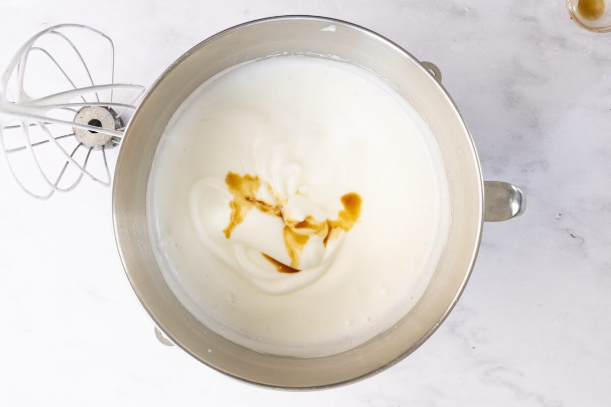 mixing bowl with vanilla and almond extracts added to egg white mixture
