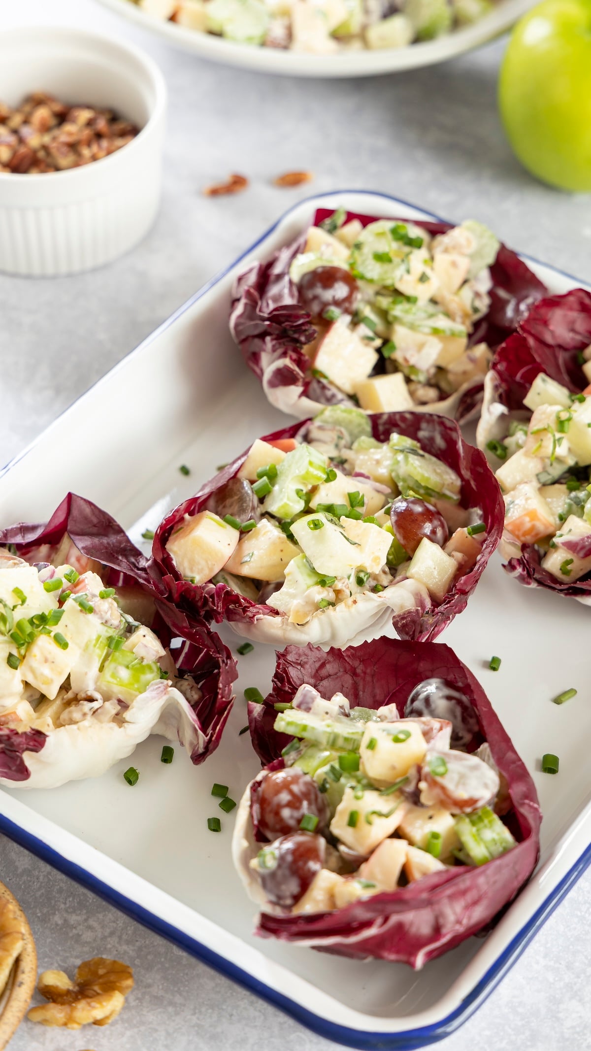 white platter with waldorf salad in radicchio lettuce cups