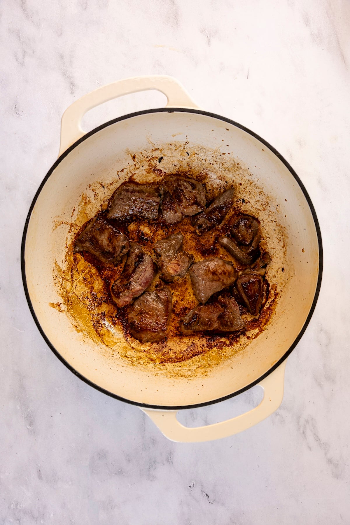Searing chunks of beef in Dutch oven.