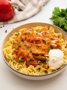 Chicken Paprikash over egg noodles with dollop of sour cream.