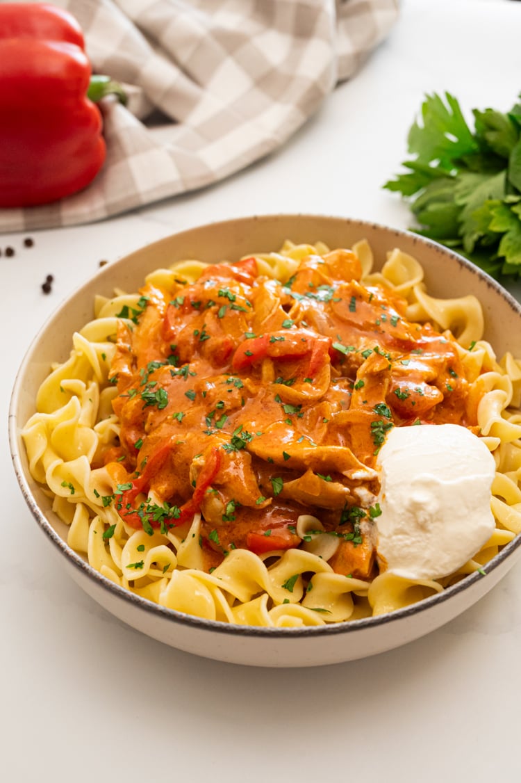 Chicken Paprikash over egg noodles with dollop of sour cream.