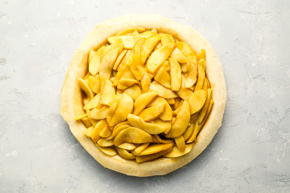 Apple pie filling piled into pie crust.