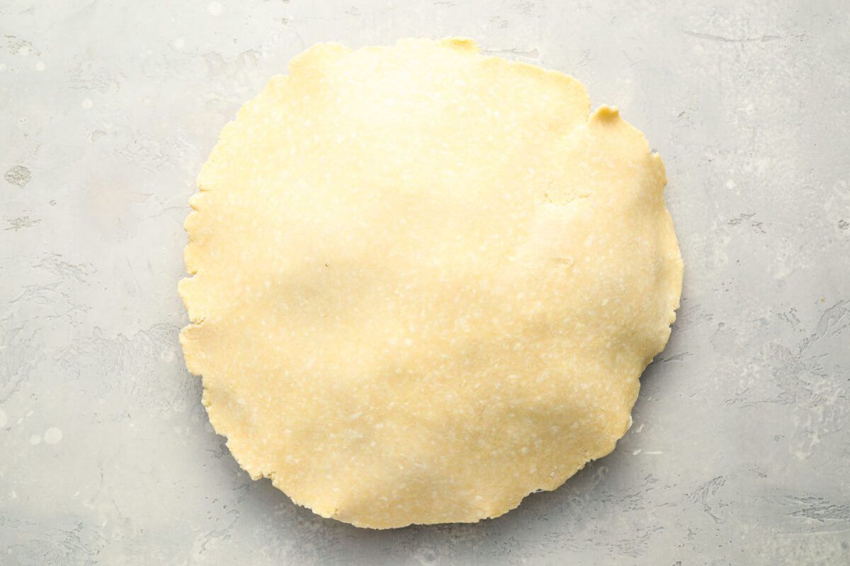 Top crust draped over apple pie filling.