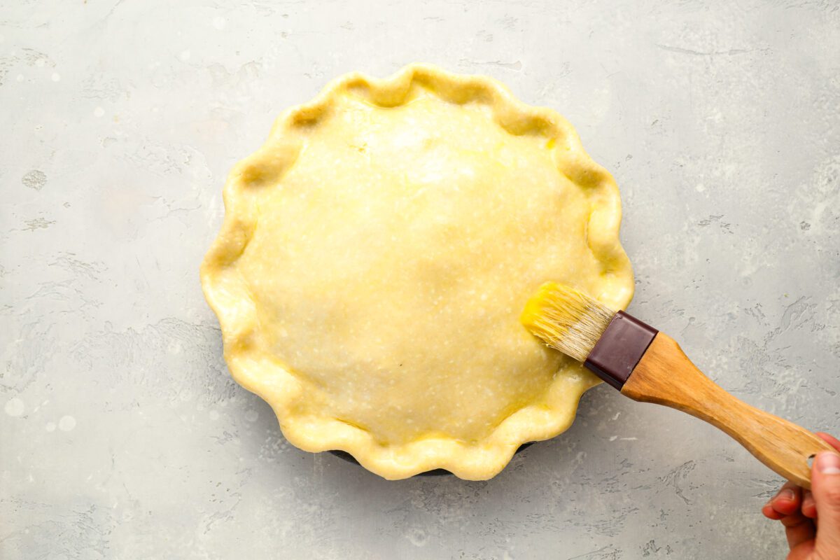 Brushing top crust with egg.