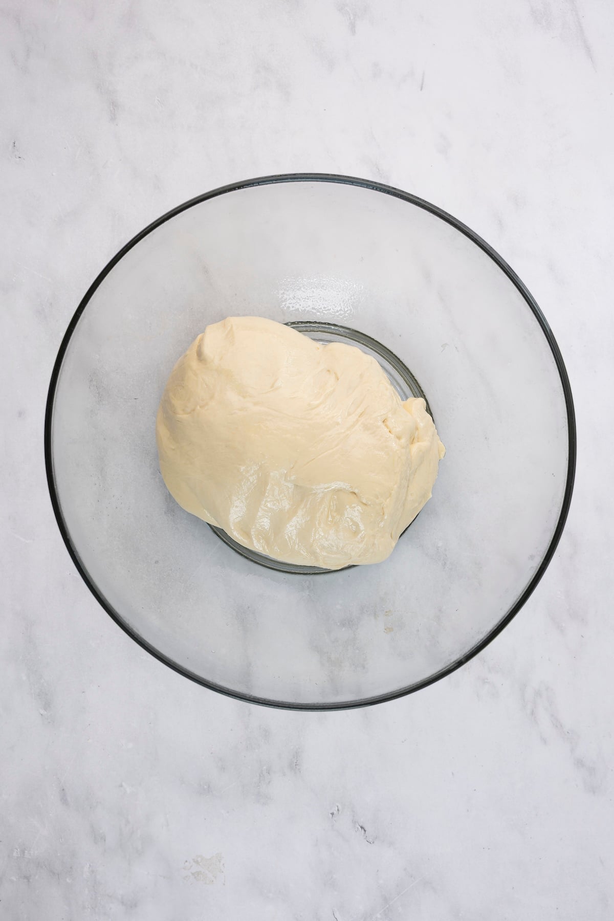 glass bowl with English muffin dough