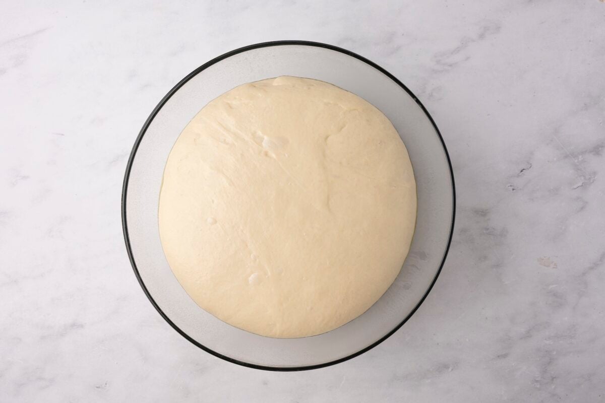 glass bowl with English muffin dough after rising