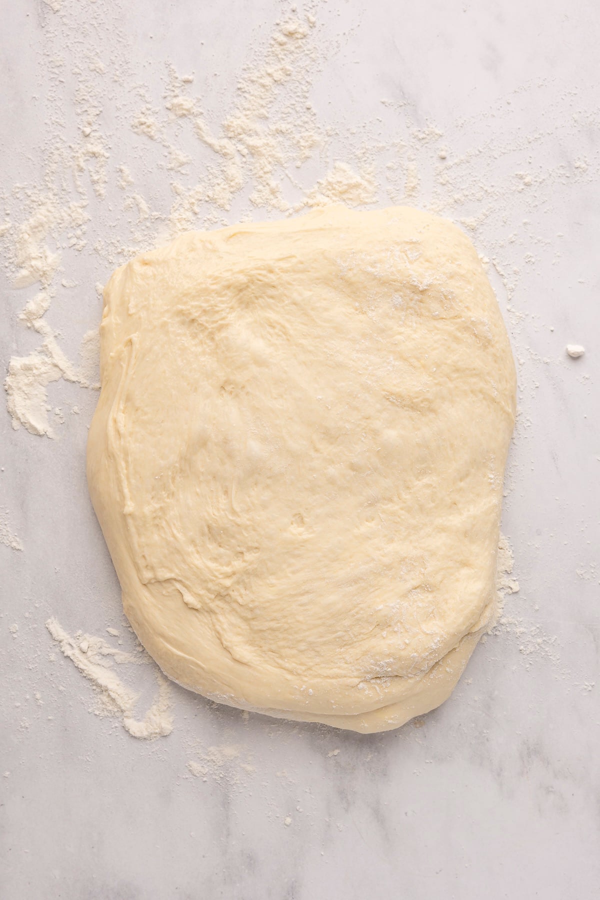 english muffin dough in rectagular shape on flour dusted surface